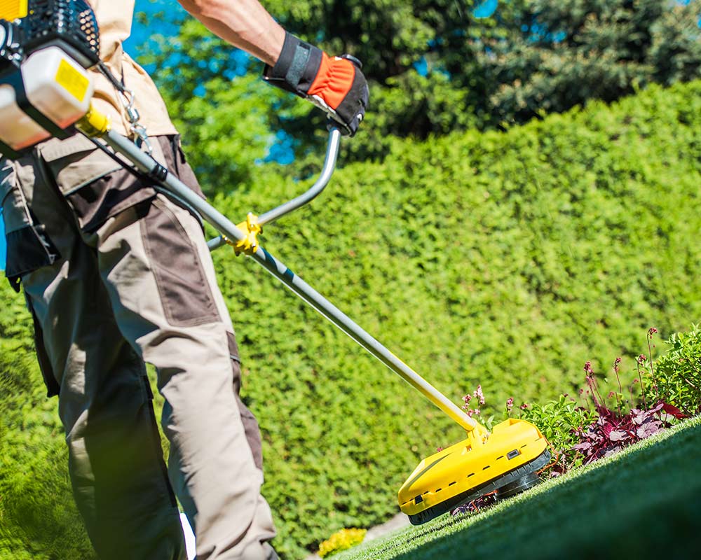 man doing lawn care with string trimmer lubbock tx